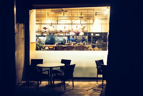 Free Chic modern cafe interior in Sochi at nighttime, view of seating and open kitchen. Stock Photo
