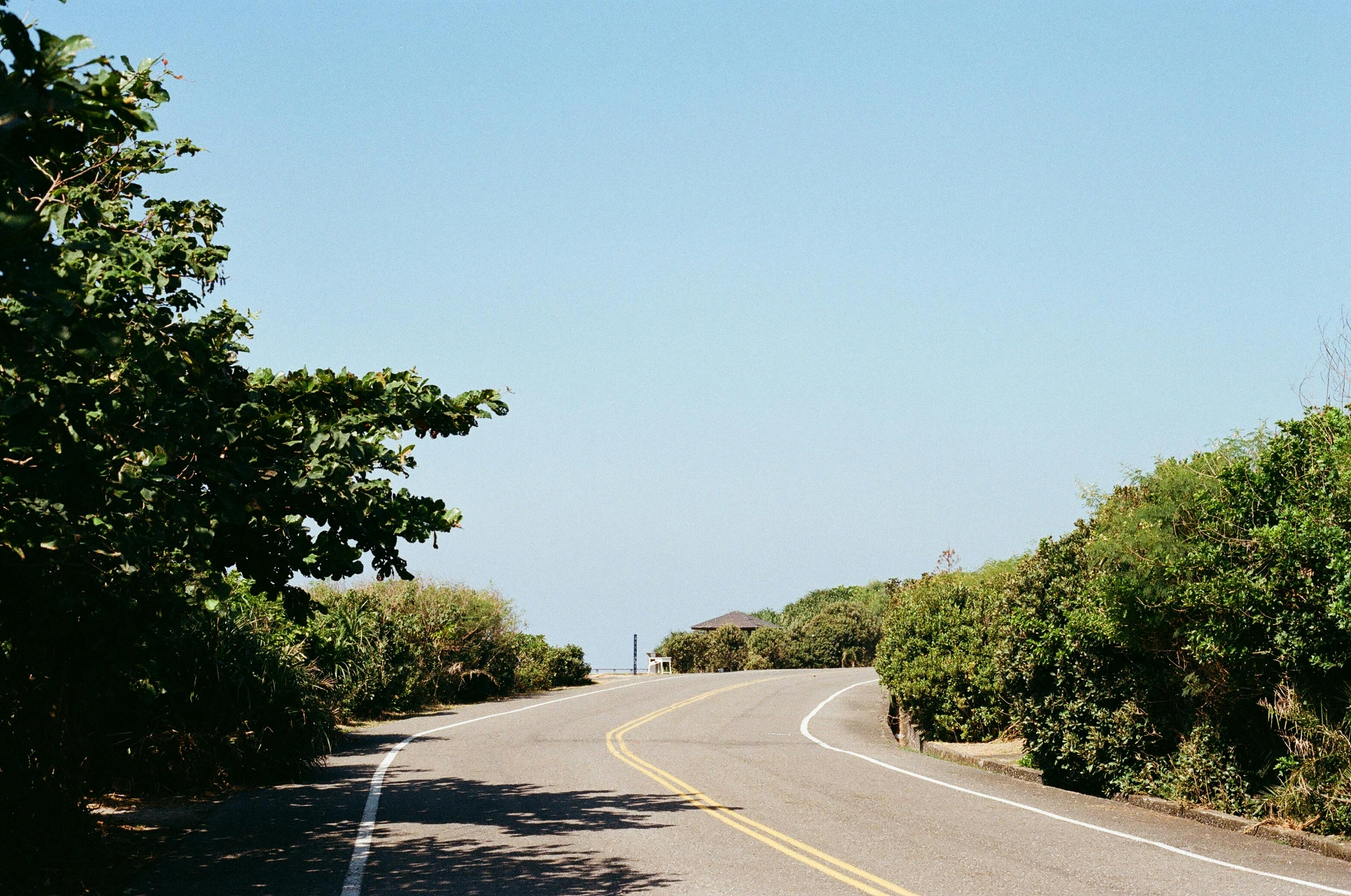 Peaceful curved road with blue sky and greenery in Taiwan perfect for travel concepts