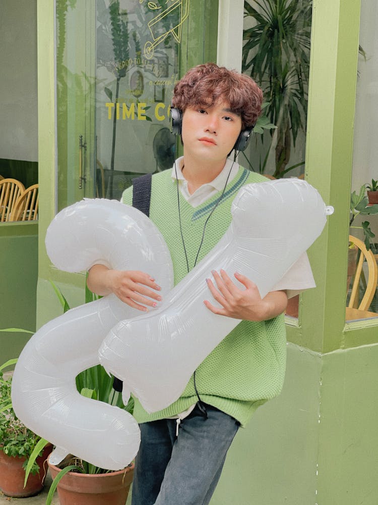 A Boy Holding White Balloons