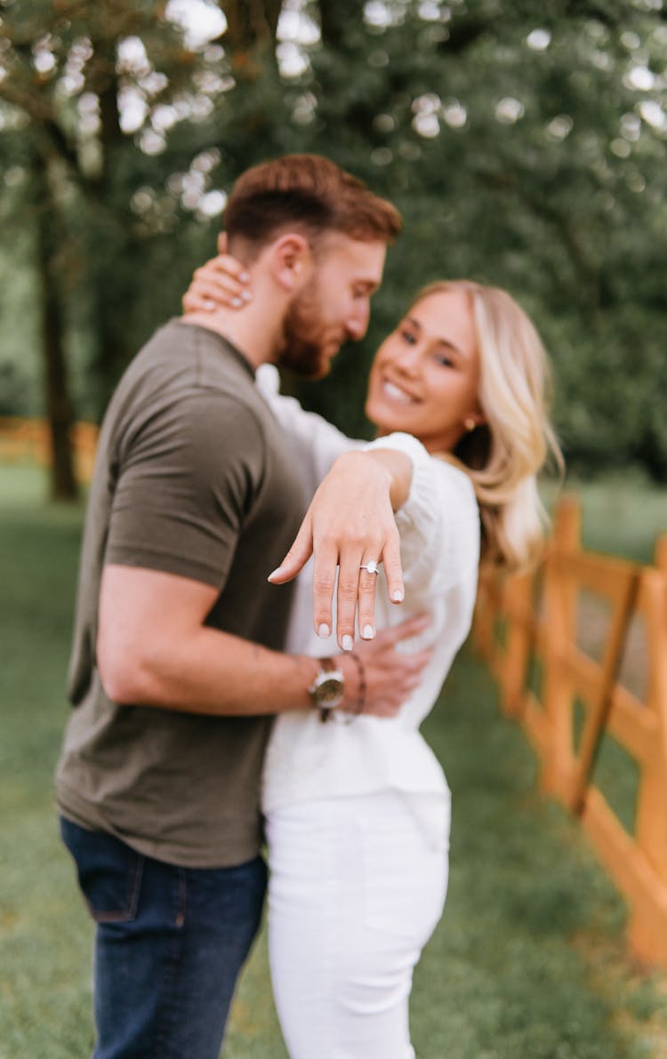 Woman Hugging Her Fiance And Showing The Engagement Ring 