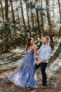 Man in White Dress Shirt and Woman in Blue Dress Standing on Forest