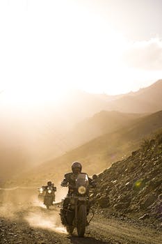 Motorcyclists explore rugged mountain paths at sunset, capturing the thrill of adventure.