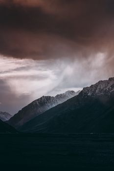 Moody mountain scene with looming storm clouds in a breathtaking natural setting.