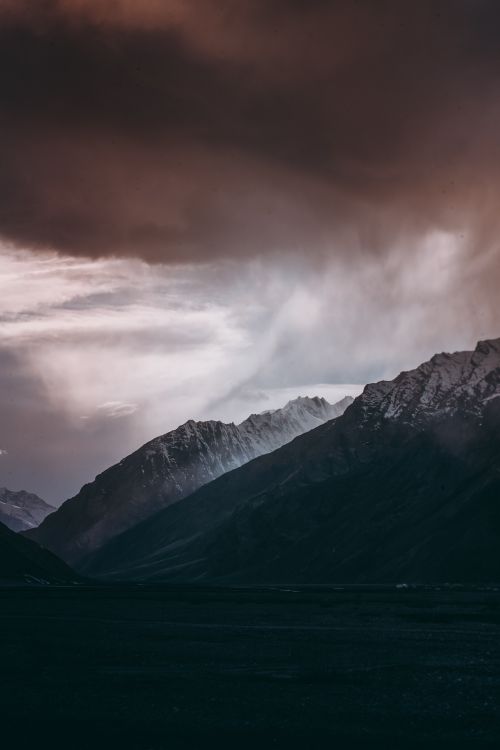 Free Moody mountain scene with looming storm clouds in a breathtaking natural setting. Stock Photo