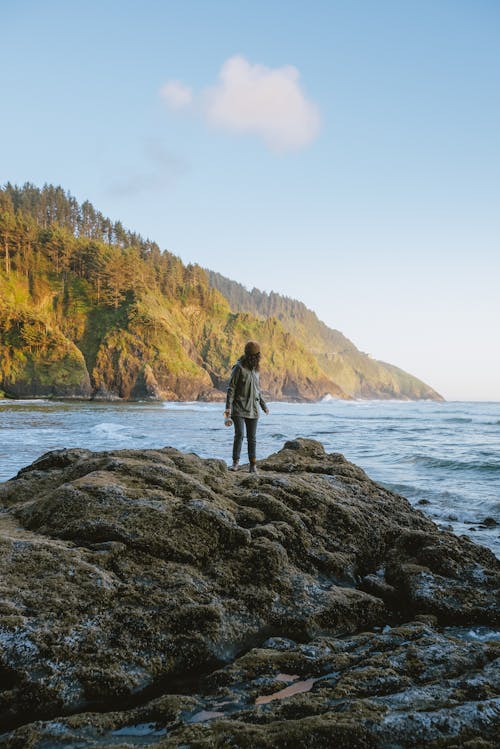 Free Person Standing on Rock Near Body of Water Stock Photo
