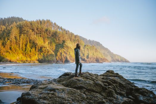 A Woman Standing on Rocky Shore