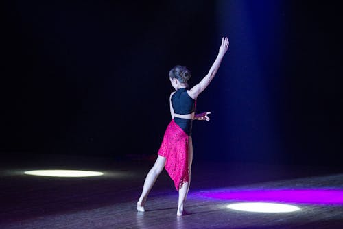Free Woman in Red Dress Dancing on Stage Stock Photo