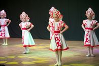 Young girls in traditional attire performing a cultural dance on stage.