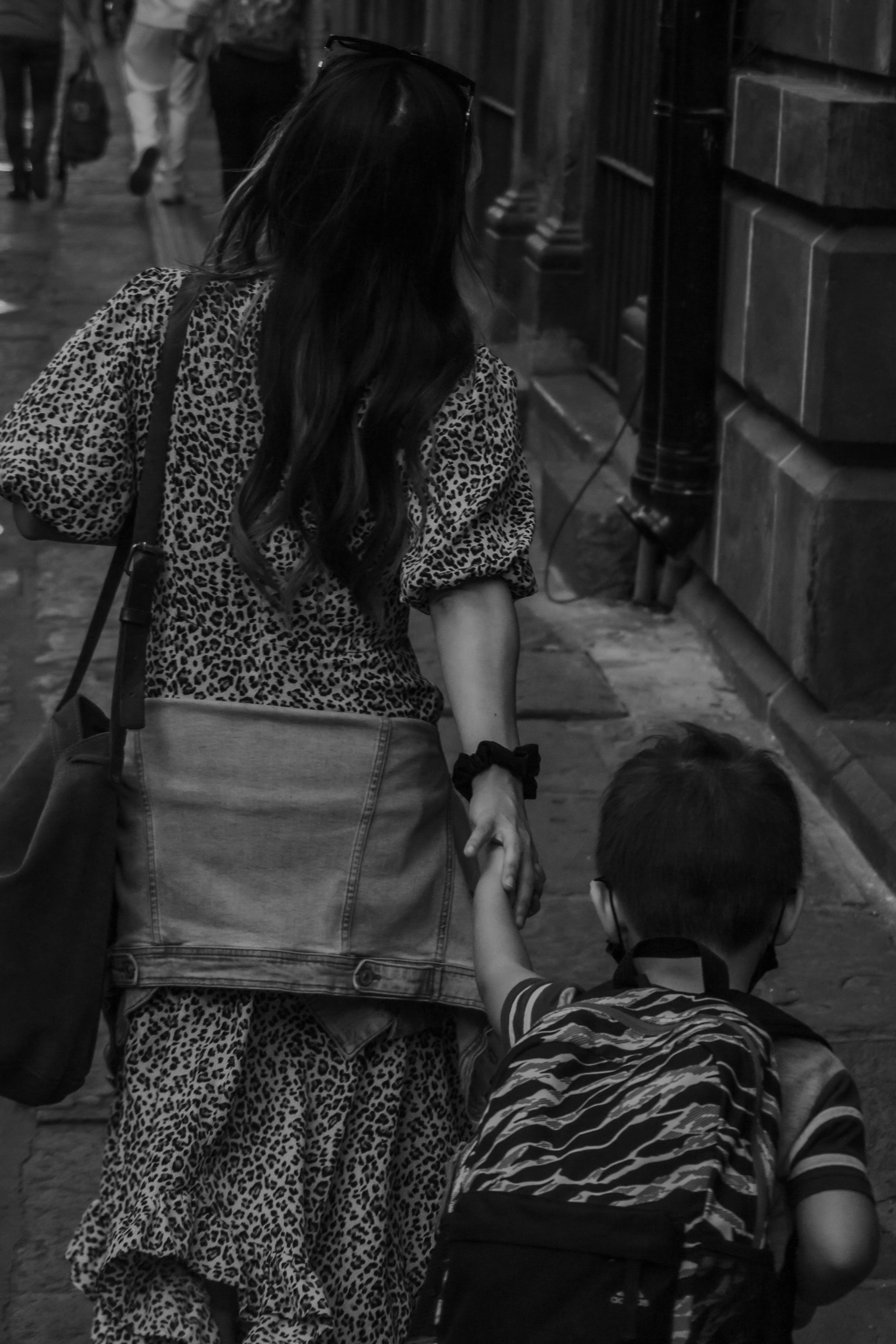 back view of a woman holding hands with her son