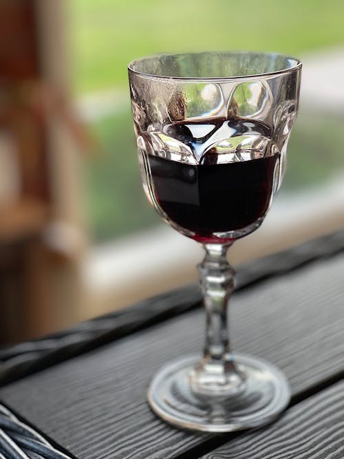A Clear Glass With Red Wine on a Wooden Table