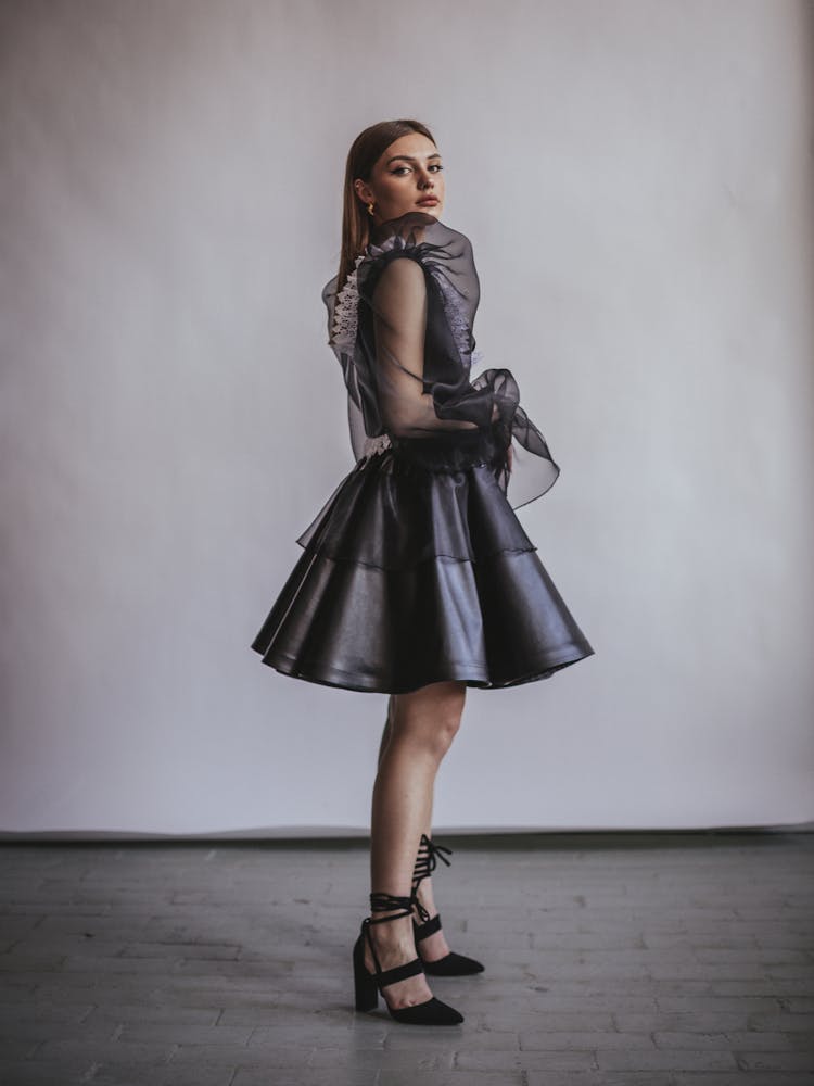 Woman Posing In A Black Flared Dress With Tulle Elements