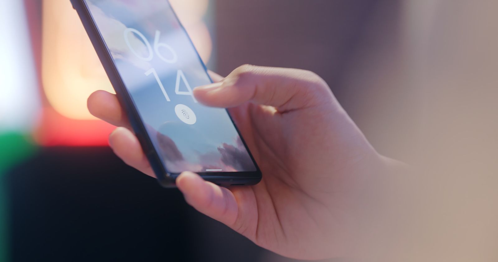 A hand holding a smartphone secured with a fingerprint lock