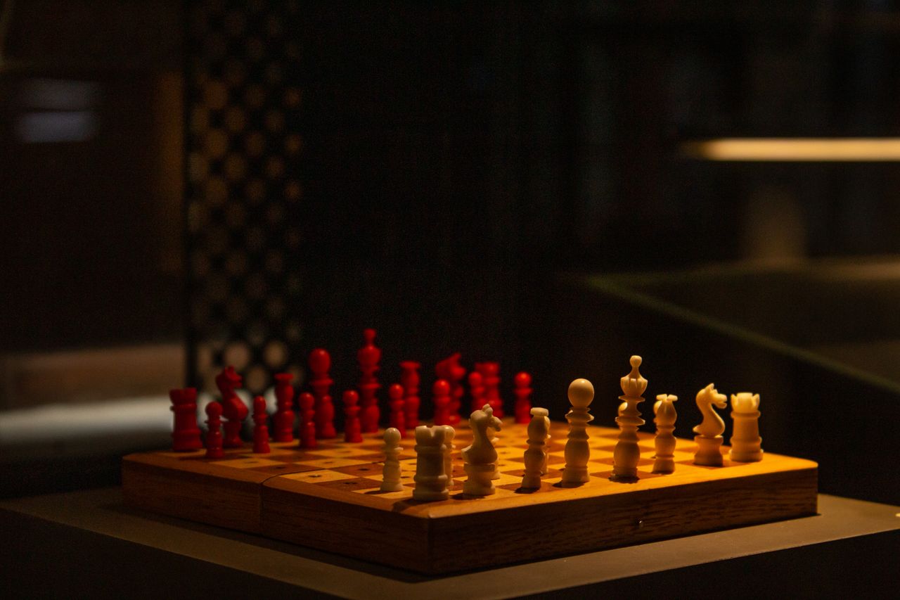 a beautifully lit chess game with red and white pieces highlighting st