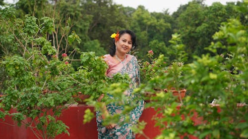 A Woman Smiling Near Green Plants