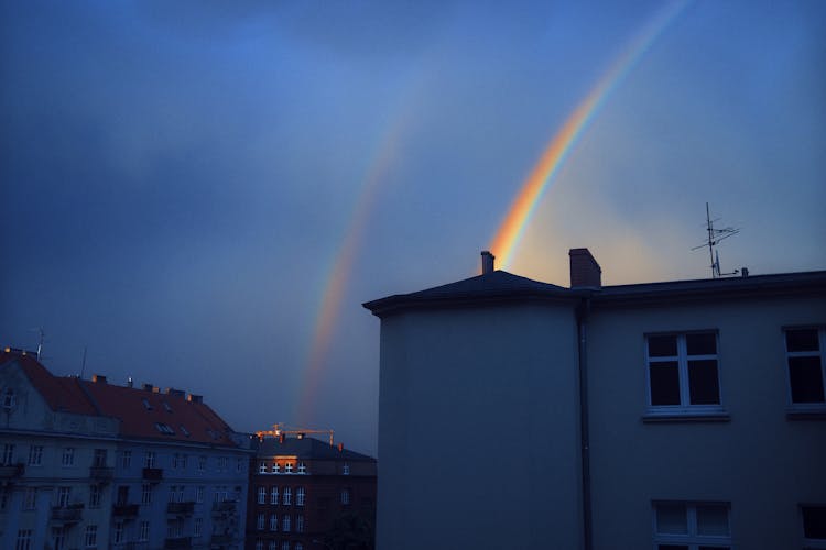 Rainbows On Sky Over Buildings