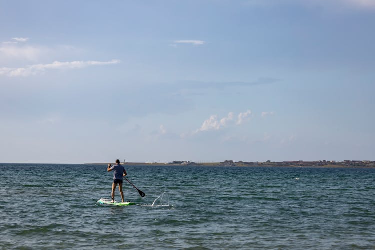 A Man Paddleboarding On The Sea