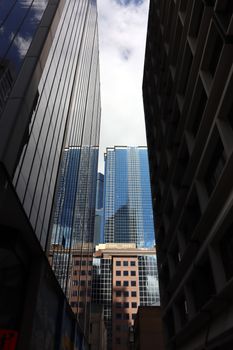 A dramatic vertical shot of Melbourne's modern skyscrapers against a vibrant sky.