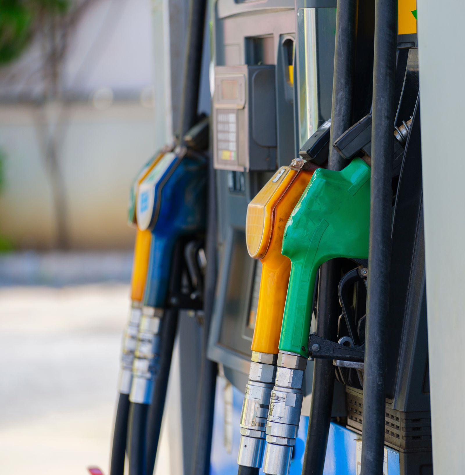 Diesel and petrol dispenser nozzles seated in their boots on a fuel island pump.