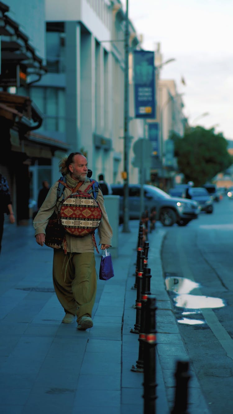 A Man Walking On The Street While Looking Over Shoulder