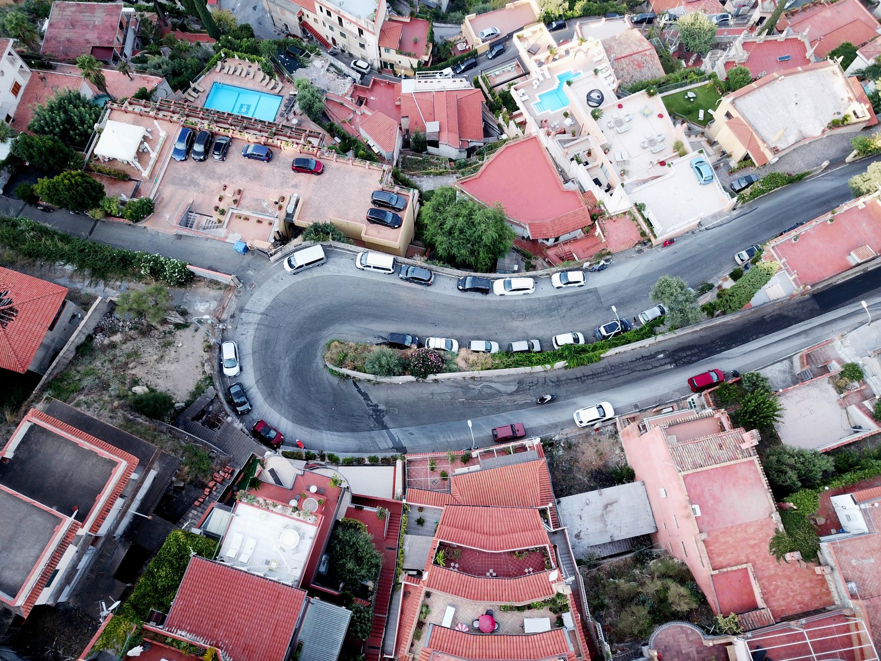 Cars on the hairpin road climbing to Taormina's rooftops, a classic stretch of driving in Sicily