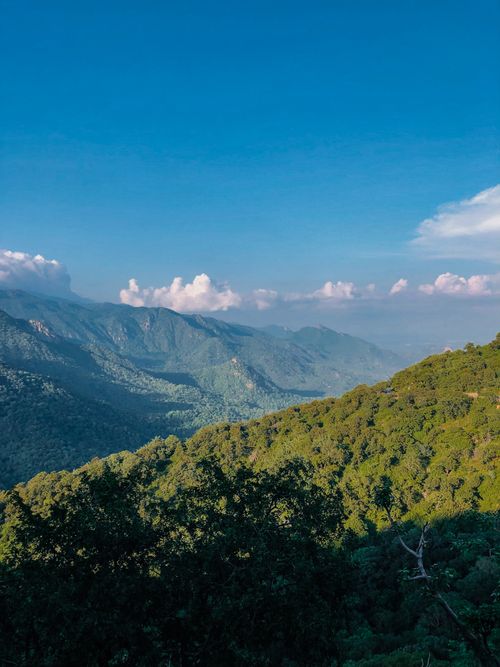 Free Scenic aerial view of Mount Abu's lush green landscape and clear blue sky. Stock Photo