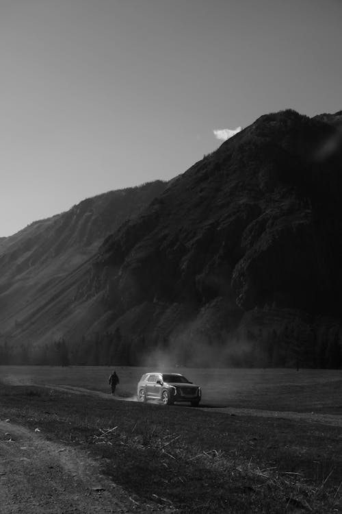Free Grayscale Photo of Car on Road Near Mountain Stock Photo