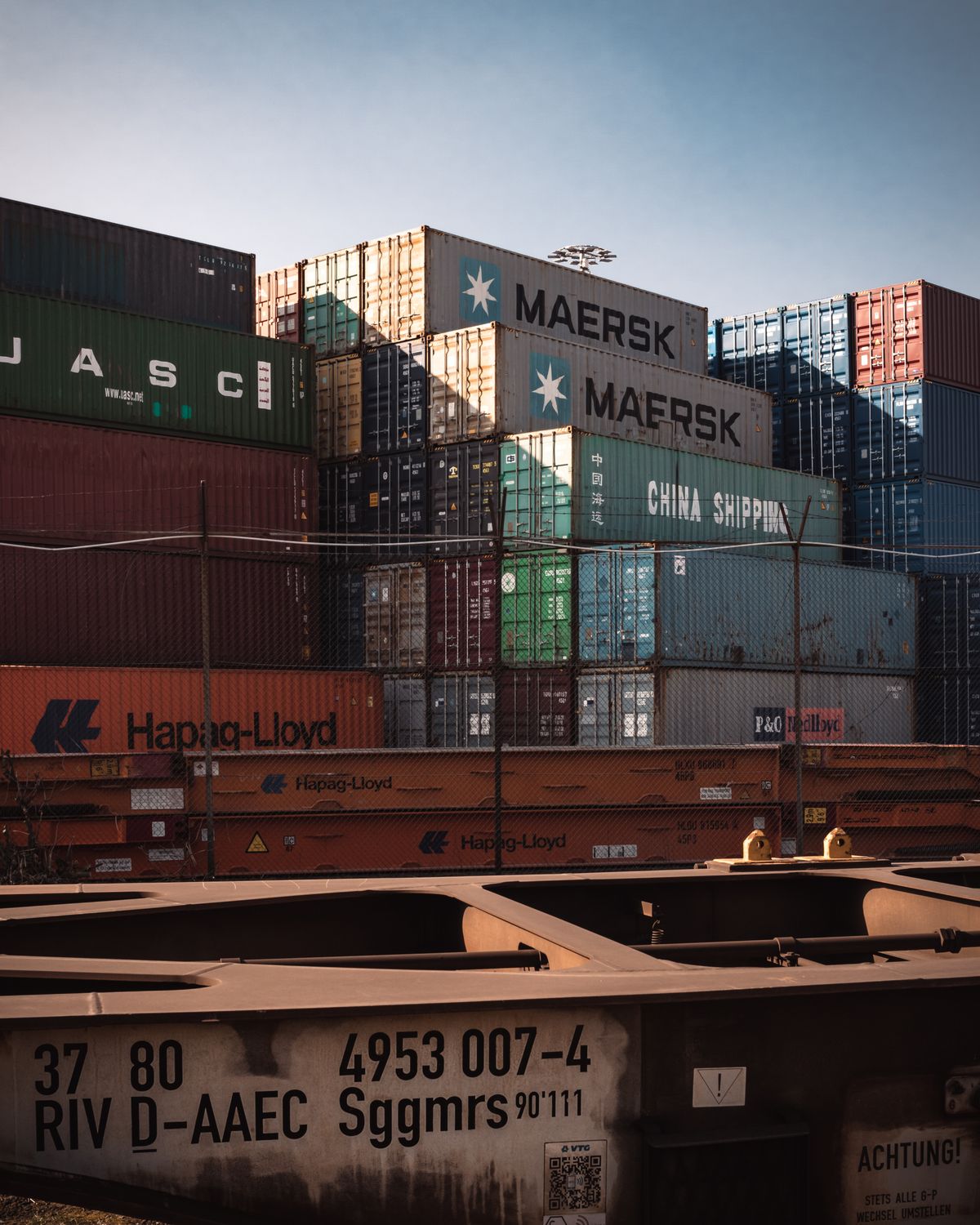 Stacks of multicoloured shipping containers at a major port terminal, showing the scale of international freight operations connecting India to UK importers