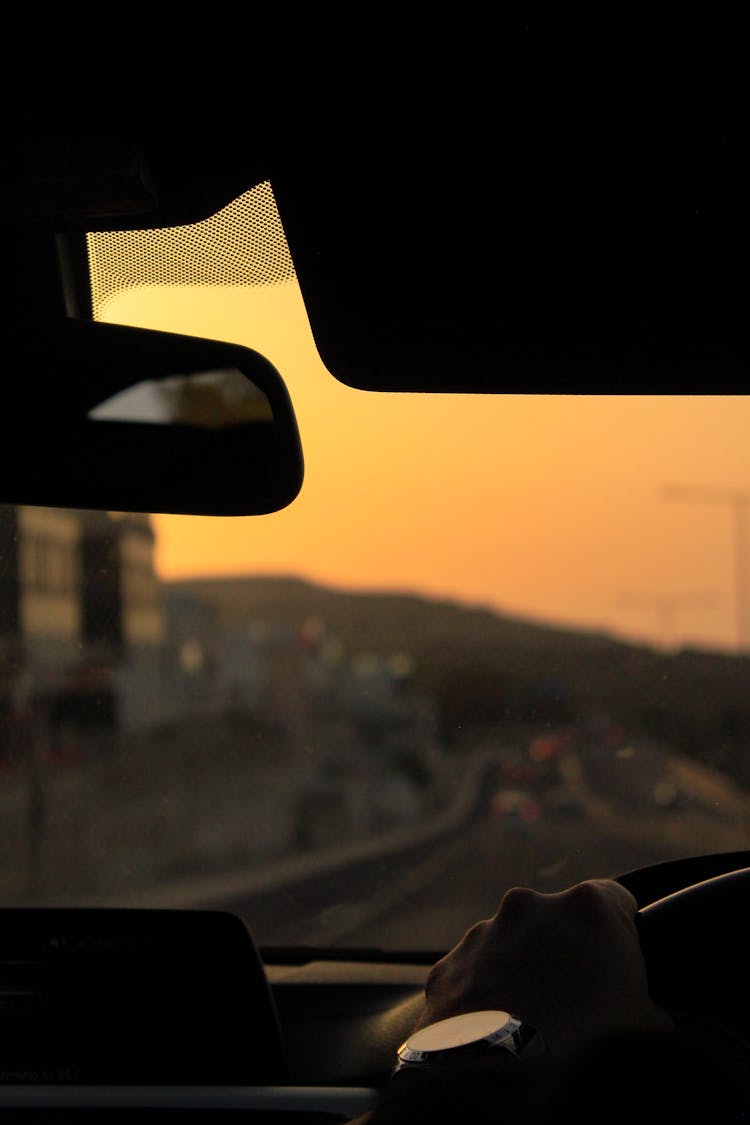 Person Driving Car During Sunset