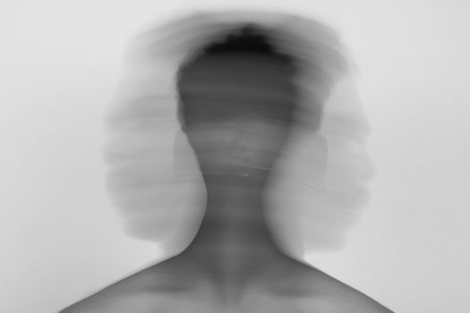 Abstract black and white portrait with blurred motion conveying emotional stress.