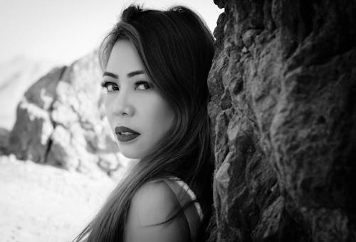 Free Monochrome Portrait of a Woman Leaning on a Rock Stock Photo