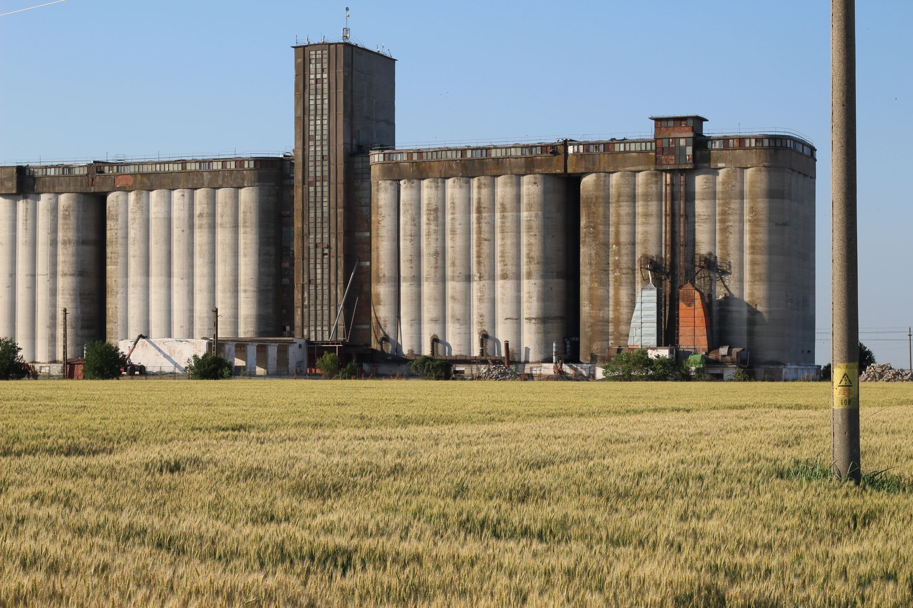 Wheat field in front of large grain silos