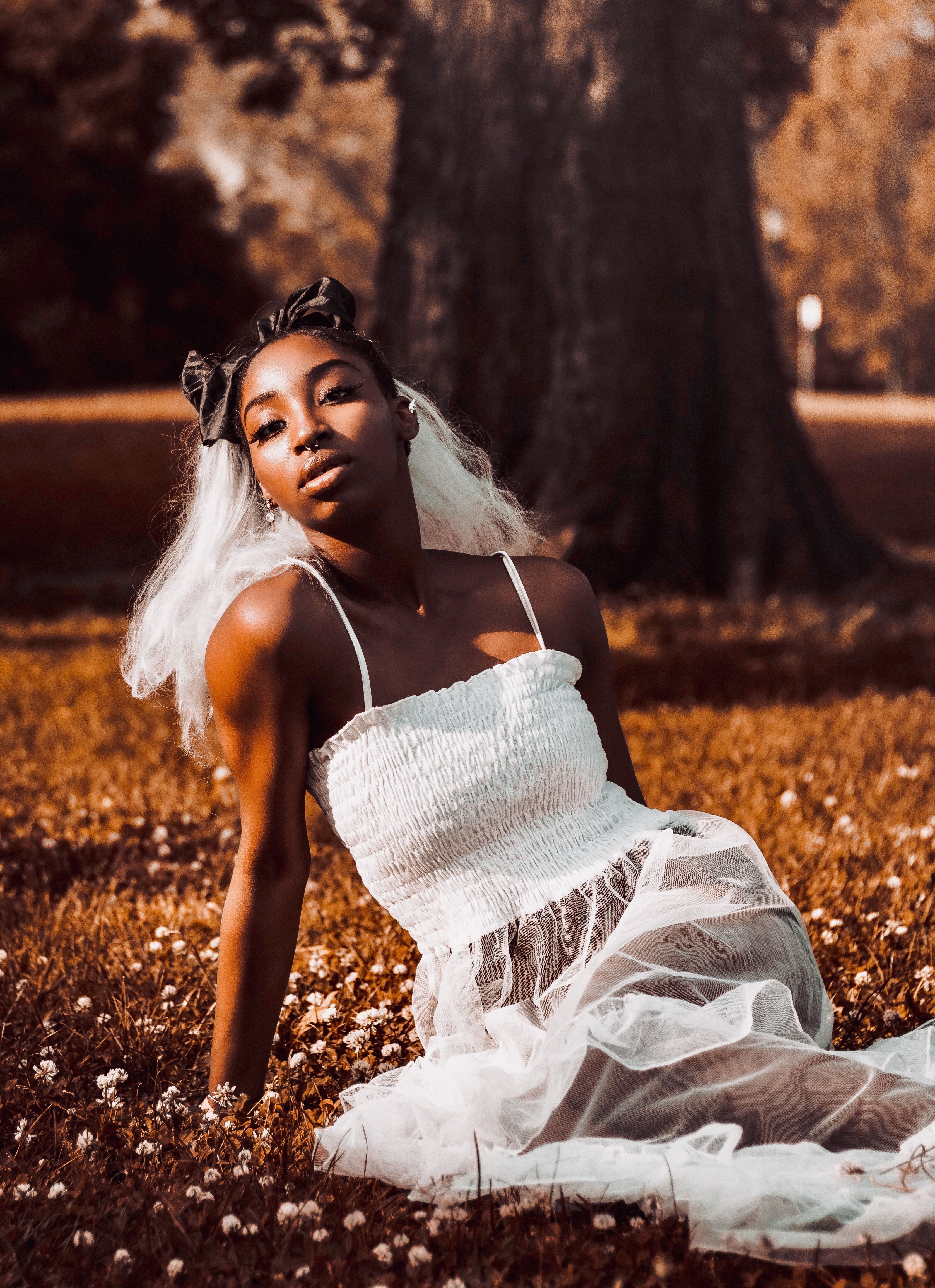 A Woman in a Black Dress Sitting on the Grass · Free Stock Photo