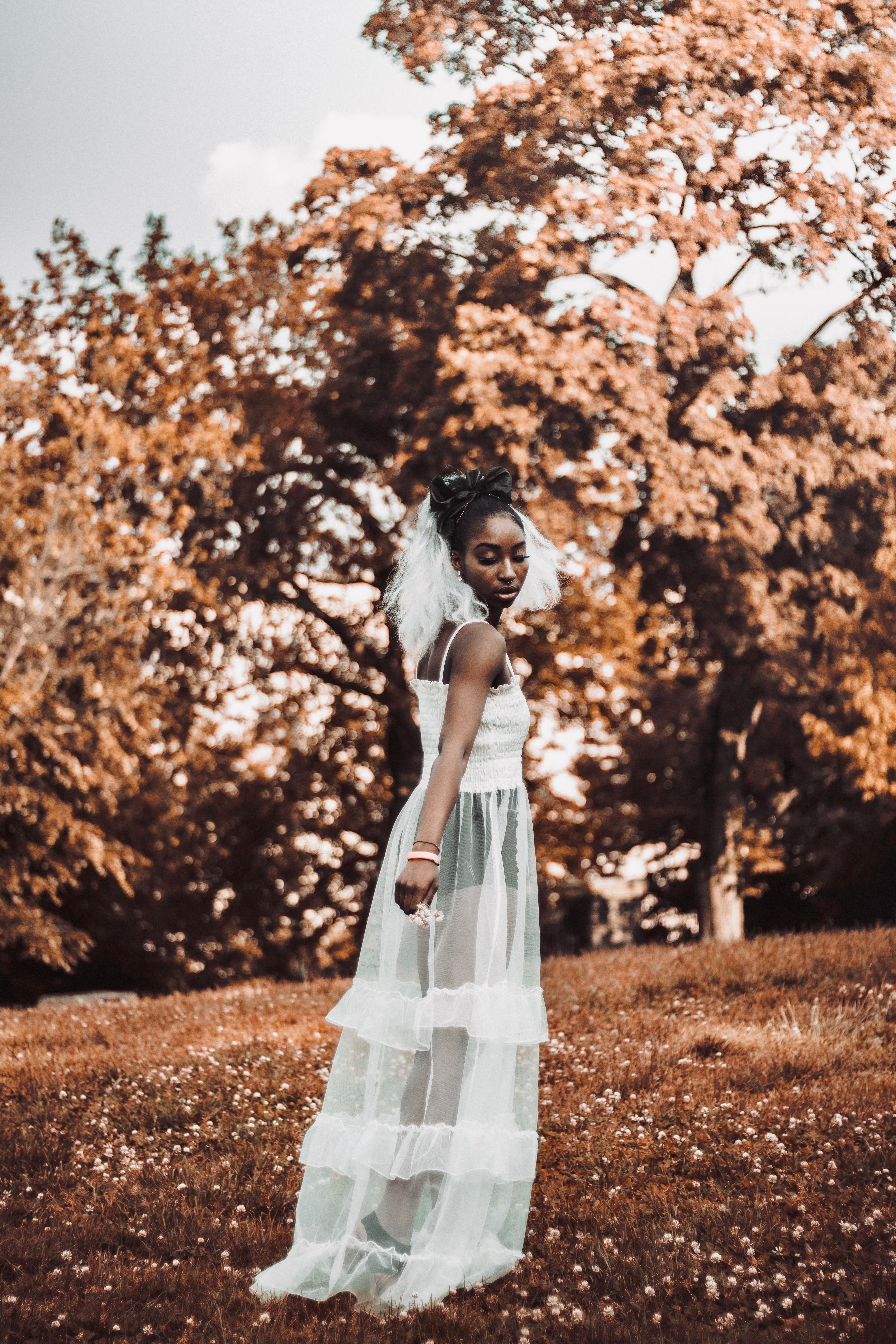 A Woman in White Dress Standing on Brown Field while Looking Afar ...