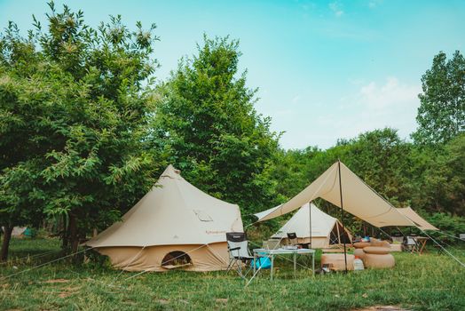 Scenic campsite with modern tents and lush greenery, perfect for a relaxing summer getaway.