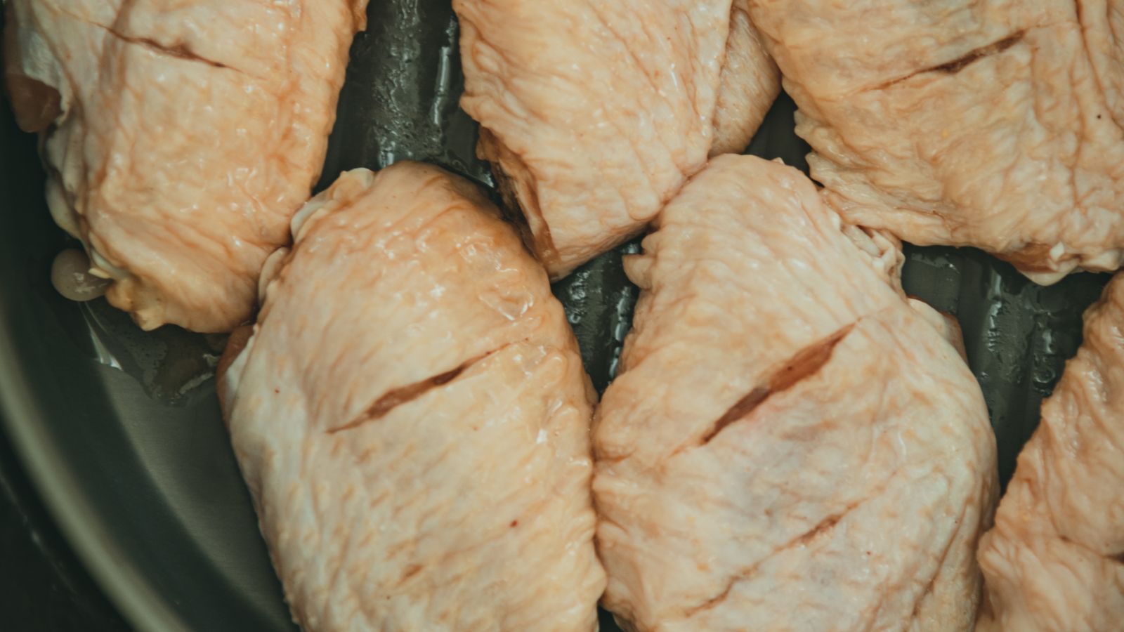 Raw chicken thighs arranged in a pan — photo by SONIC on Pexels Raw chicken thighs arranged in a pan