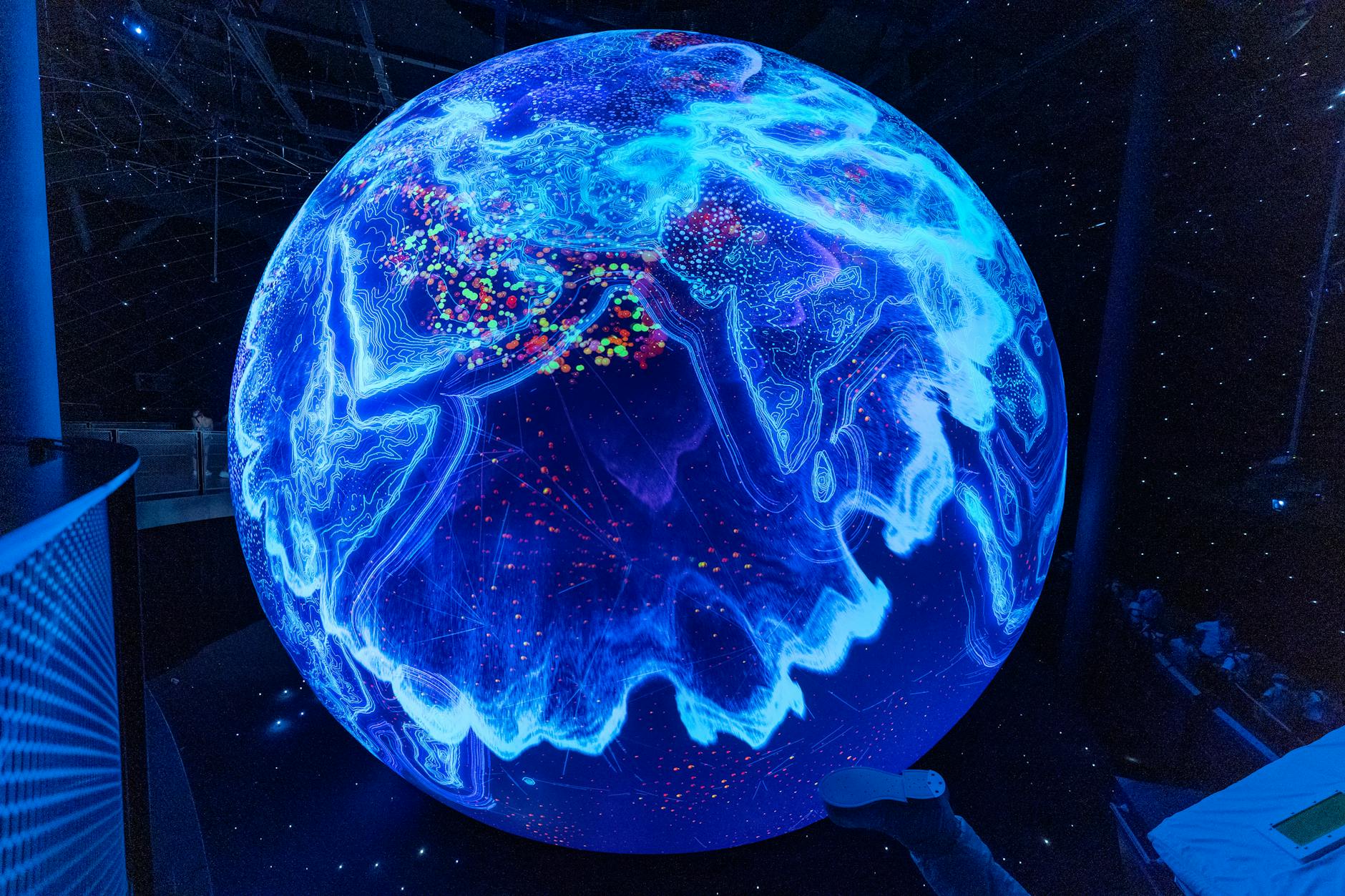 A vibrant illuminated globe display showcasing technological advancements at a science museum.