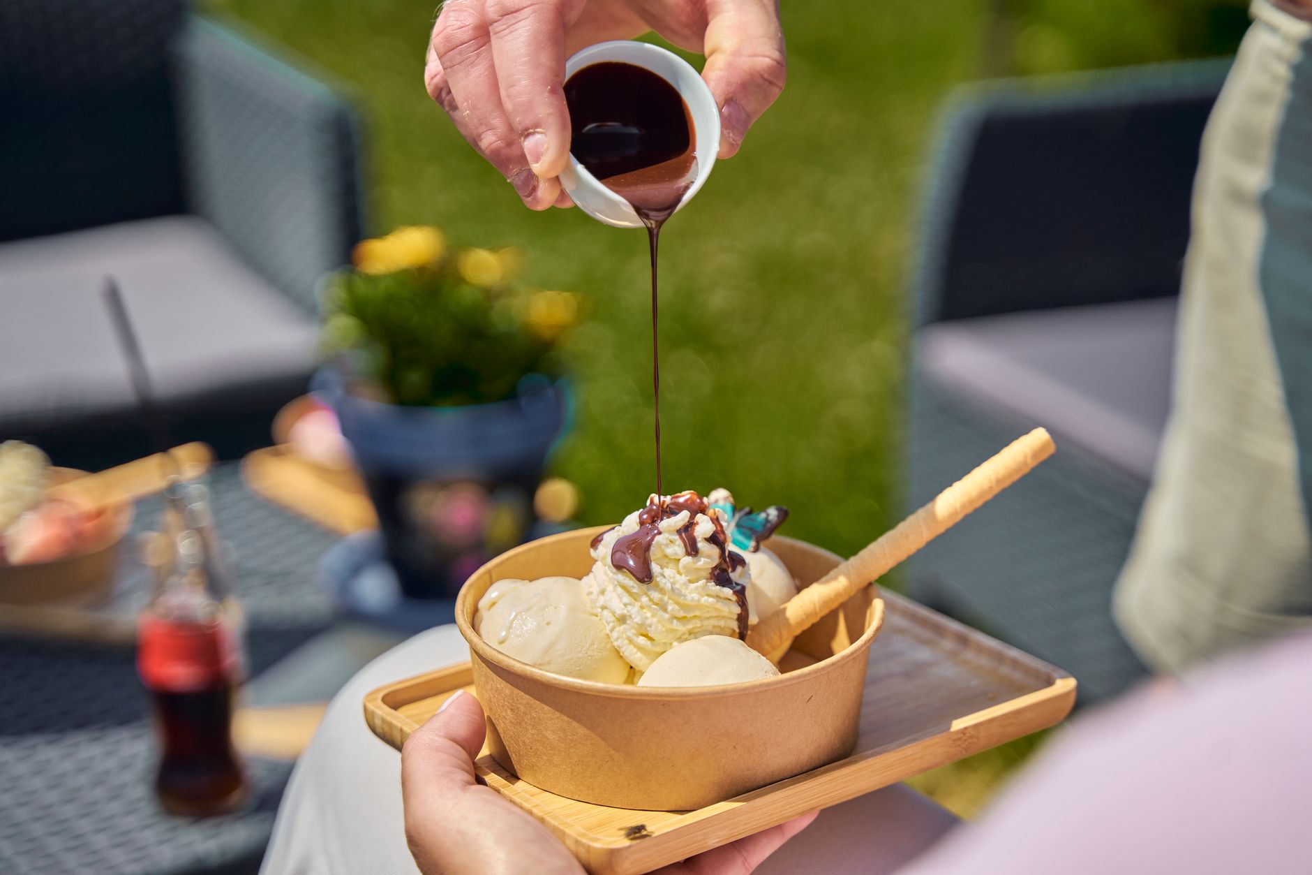 Bowl of vanilla ice cream topped with caramel sauce and nuts
