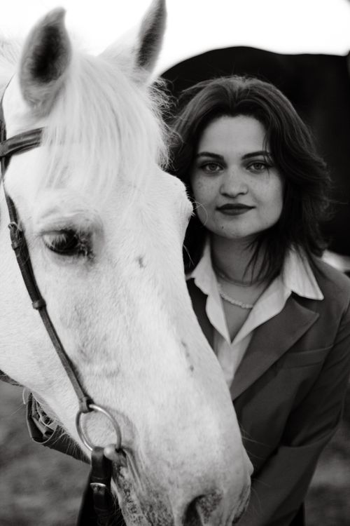 Free Elegant black and white portrait featuring a woman alongside a white horse. Stock Photo
