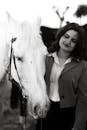Woman in Brown Blazer Standing Beside White Horse
