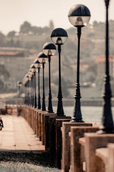 A scenic view of street lamps along a pier in A Coruña, Spain, at dusk.