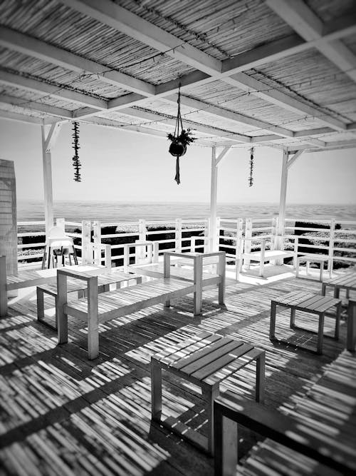 Free White Wooden Chairs on Wooden Deck in Grayscale Photography Stock Photo