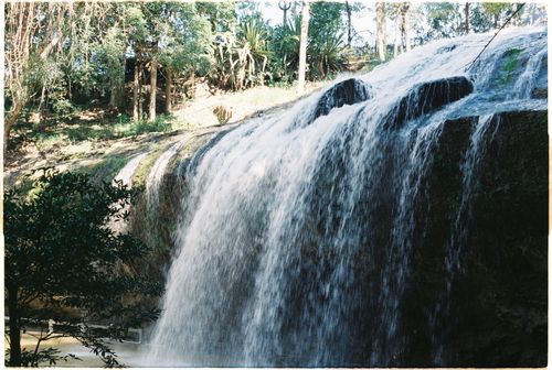 Free A serene view of a cascading waterfall in a lush forest setting. Stock Photo