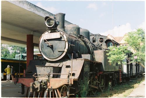 Free Old steam engine locomotive resting at a historical train station under the bright sky. Stock Photo