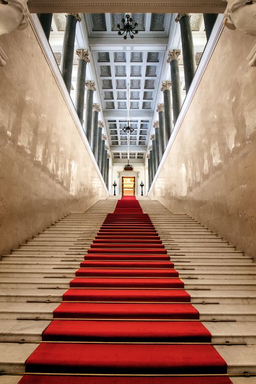 Free Grand hallway with a red carpet on marble stairs in a historic building, showcasing architectural elegance. Stock Photo