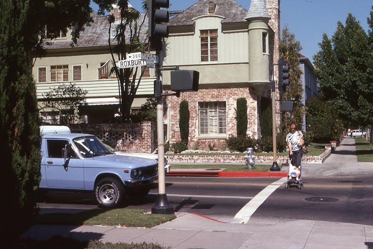 Woman Crossing Street And Pushing Baby Stroller