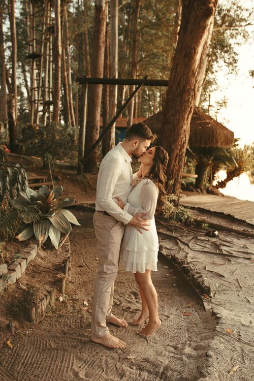 Free A loving couple shares a romantic kiss surrounded by nature in a serene forest setting. Stock Photo