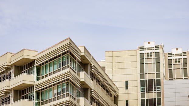 A modern building with angular glass facade against the clear sky.