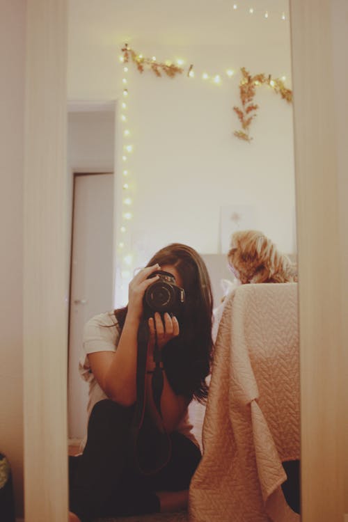 Woman Taking a Photo in a Mirror with a Camera Covering her Face