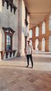 Man in White Dress Shirt and Black Pants Standing on Brown Concrete Floor