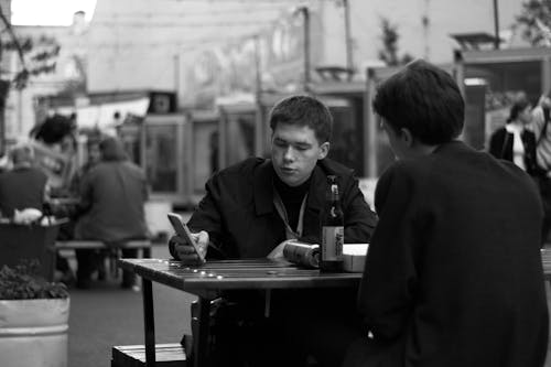 Men Sitting in Bar Using Phone